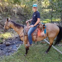 a young lady on horseback smiling at the camera